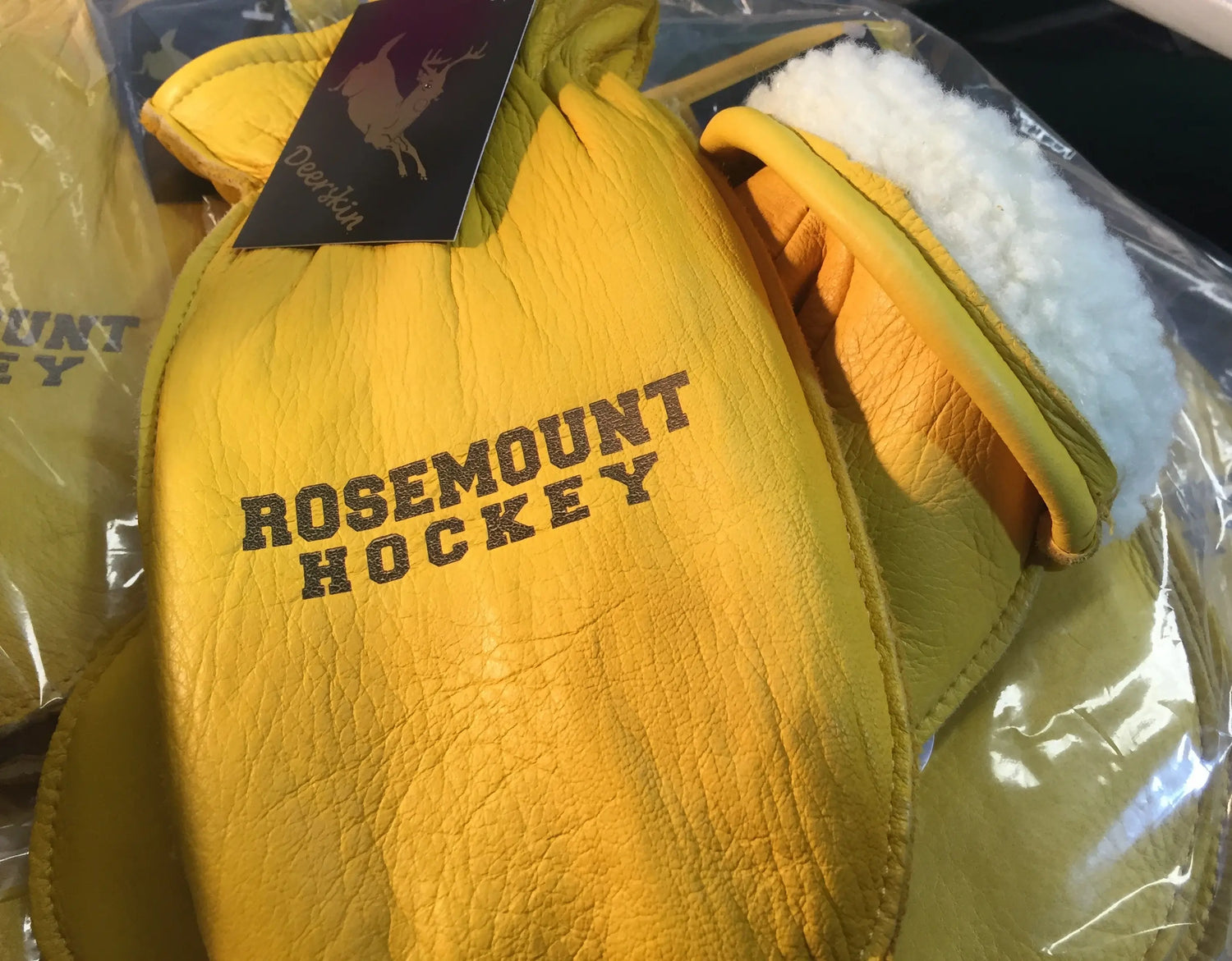 Yellow hockey glove with 'Rosemount Hockey' text on a clear background
